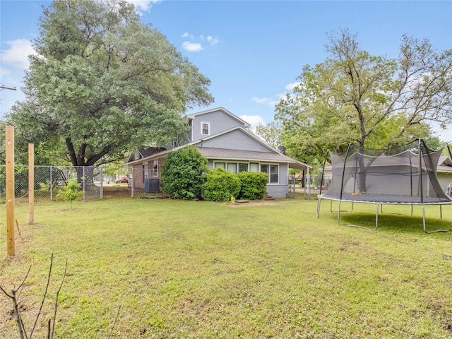 view of yard with fence and a trampoline