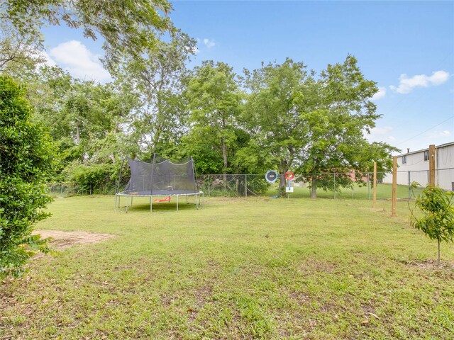 view of yard featuring fence and a trampoline