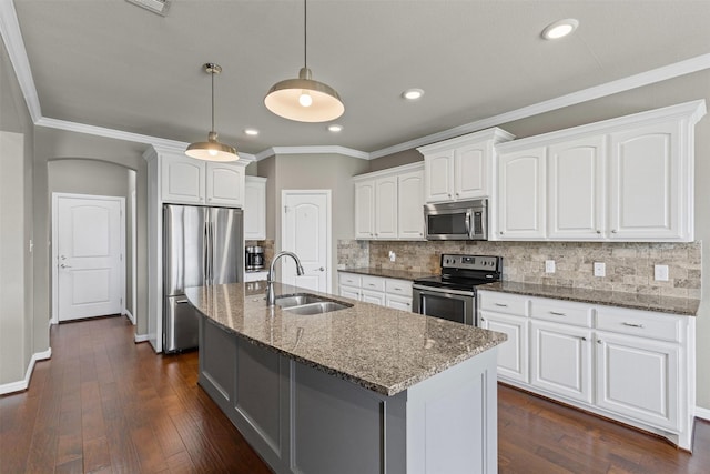kitchen with dark stone counters, a sink, decorative backsplash, white cabinets, and appliances with stainless steel finishes