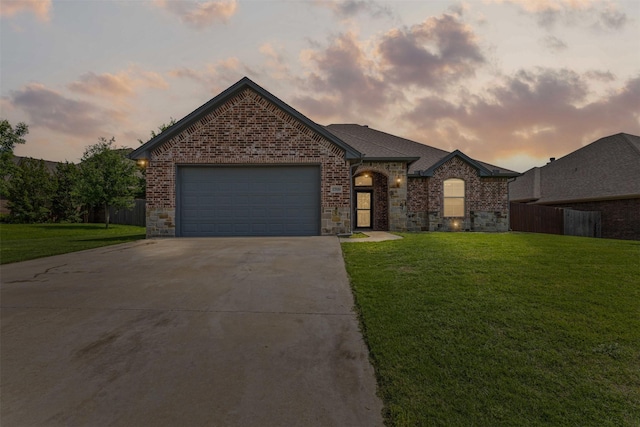 view of front of property featuring fence, driveway, an attached garage, and a front yard