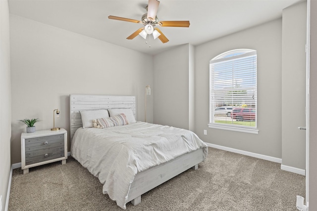 bedroom with a ceiling fan, carpet flooring, multiple windows, and baseboards