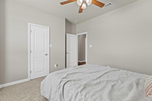 carpeted bedroom featuring baseboards, visible vents, and a ceiling fan