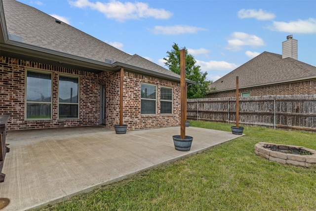 view of yard with a patio, fence, and an outdoor fire pit