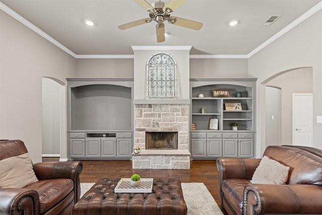 living area with crown molding, dark wood-style floors, arched walkways, and ceiling fan