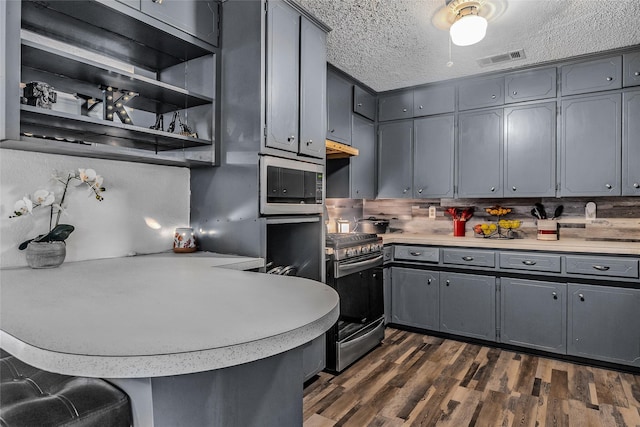kitchen featuring appliances with stainless steel finishes, visible vents, light countertops, a peninsula, and gray cabinetry