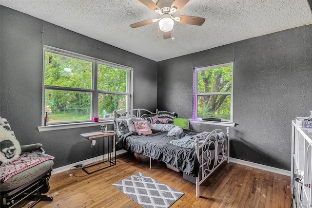 bedroom featuring a textured wall and hardwood / wood-style flooring