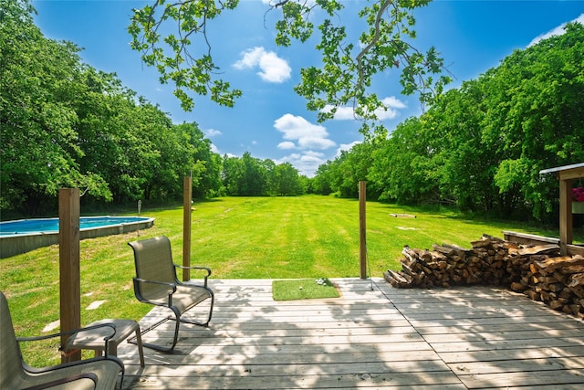 wooden deck with a lawn and an outdoor pool