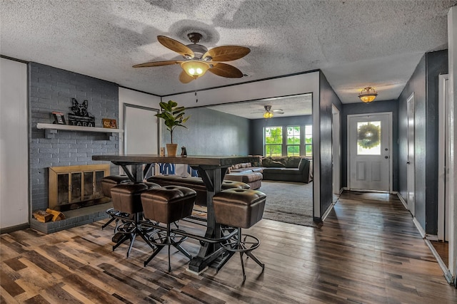 bar with baseboards, a textured ceiling, dark wood finished floors, and ceiling fan