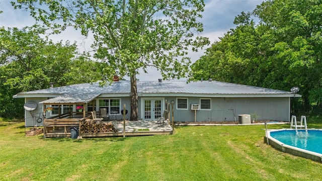 rear view of house with a yard, french doors, an outdoor pool, and a wooden deck