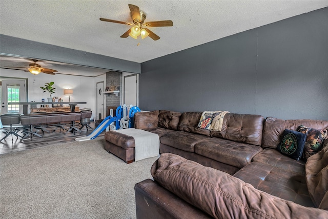 living area with a ceiling fan and a textured ceiling