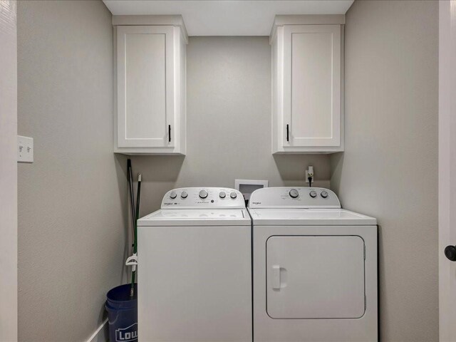 washroom featuring washer and dryer and cabinet space
