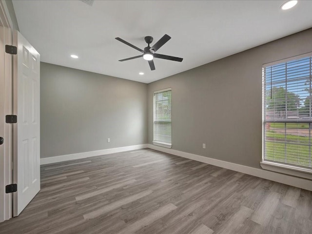 spare room featuring baseboards, recessed lighting, wood finished floors, and ceiling fan