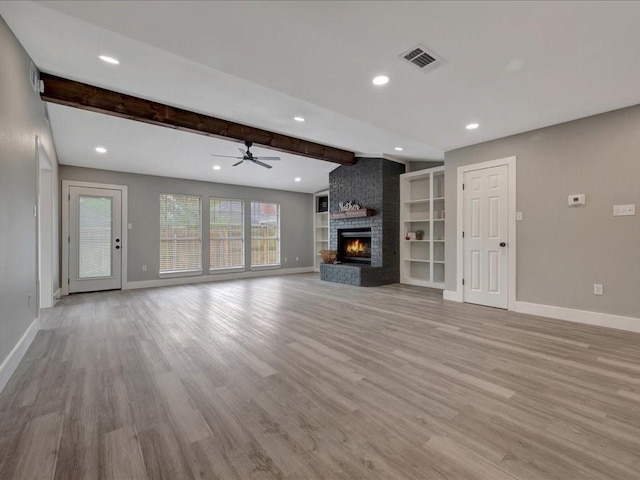 unfurnished living room with visible vents, light wood finished floors, beamed ceiling, and baseboards