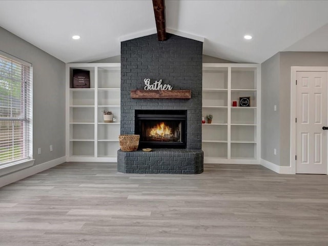 unfurnished living room featuring a fireplace, wood finished floors, lofted ceiling with beams, and baseboards