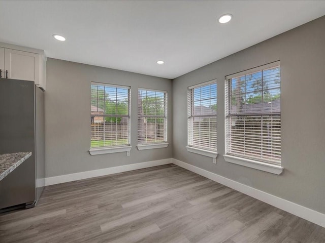 unfurnished dining area featuring baseboards and plenty of natural light