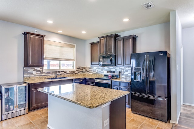 kitchen with black appliances, a sink, beverage cooler, dark brown cabinetry, and recessed lighting