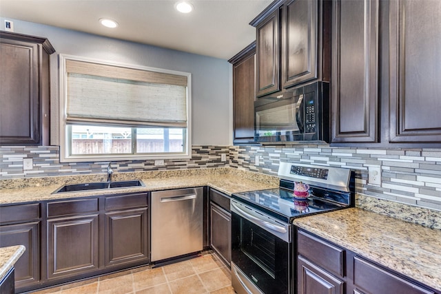 kitchen with stainless steel appliances, a sink, dark brown cabinetry, tasteful backsplash, and recessed lighting