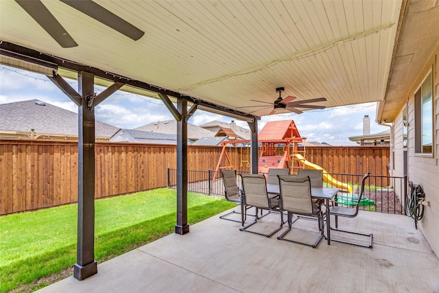 view of patio with a playground, outdoor dining space, and a ceiling fan