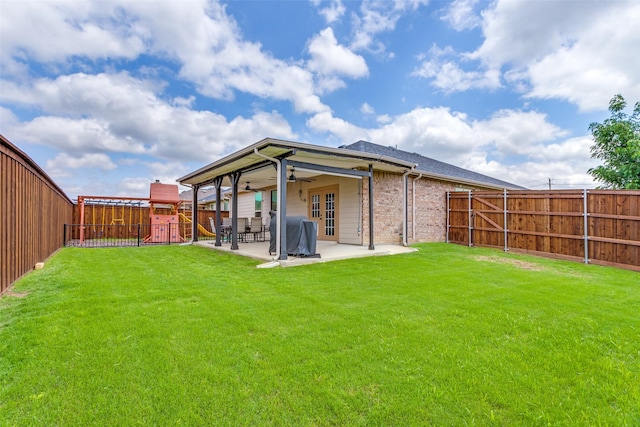 rear view of house with a ceiling fan, a playground, a patio area, brick siding, and french doors