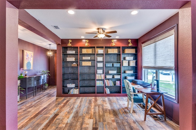 office featuring a textured wall, wood-type flooring, recessed lighting, and a ceiling fan