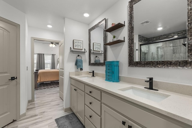 full bathroom with visible vents, a shower stall, double vanity, and a sink
