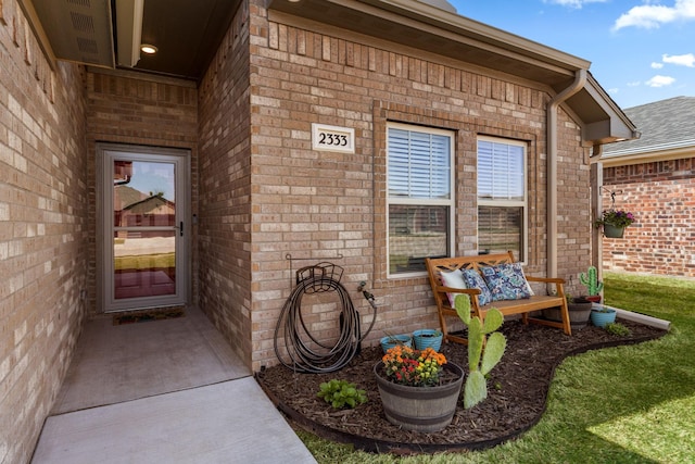 view of exterior entry featuring brick siding