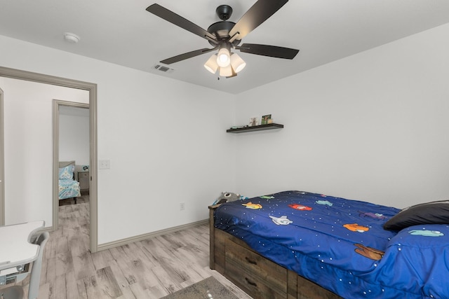 bedroom with wood finished floors, visible vents, a ceiling fan, and baseboards