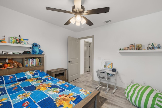 bedroom with baseboards, visible vents, wood finished floors, and a ceiling fan