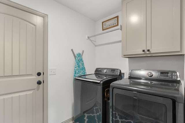clothes washing area with cabinet space and independent washer and dryer