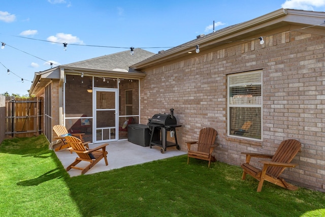 back of property featuring a patio, fence, a sunroom, and a lawn