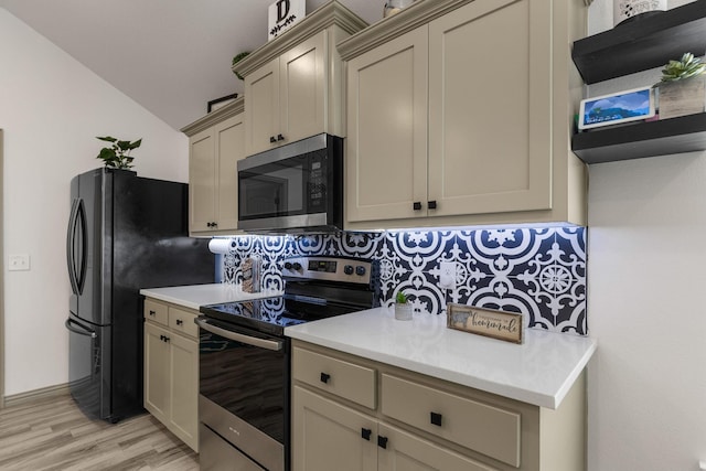 kitchen featuring tasteful backsplash, stainless steel appliances, light wood-style floors, light countertops, and lofted ceiling