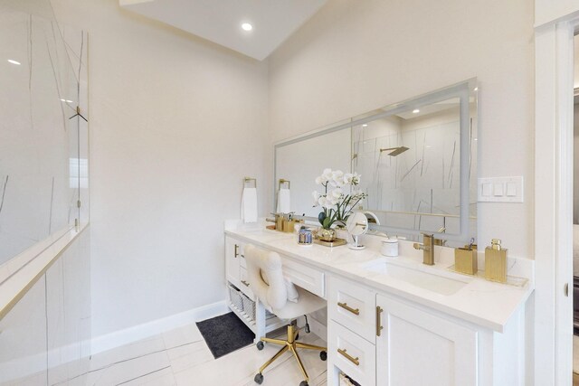 full bathroom with double vanity, tile patterned flooring, a sink, baseboards, and a marble finish shower
