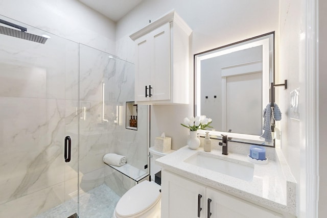 bathroom with a marble finish shower, vanity, and toilet