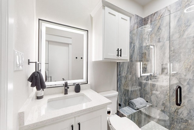 full bathroom featuring vanity, a stall shower, and toilet