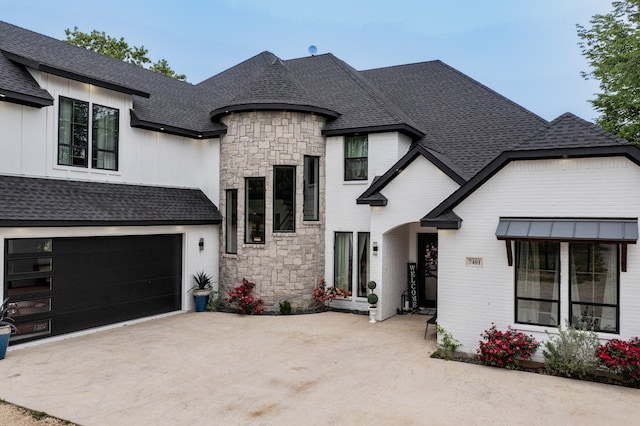 french provincial home with roof with shingles, concrete driveway, and stone siding