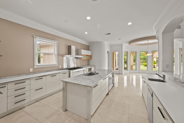 kitchen featuring a sink, crown molding, wall chimney exhaust hood, and visible vents