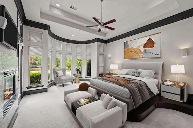 bedroom featuring visible vents, a ceiling fan, access to outside, a raised ceiling, and carpet flooring