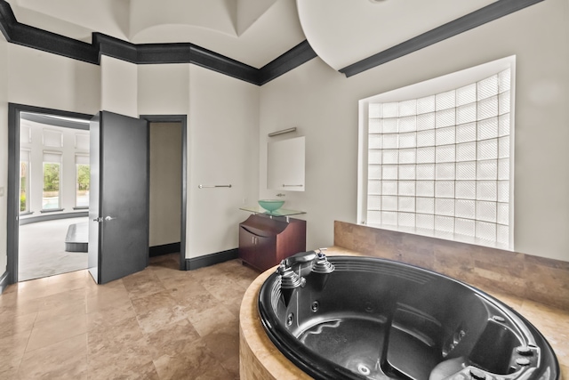 full bath with a tub with jets, ornamental molding, a high ceiling, and vanity