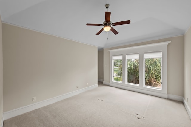 empty room featuring crown molding, carpet floors, baseboards, and ceiling fan