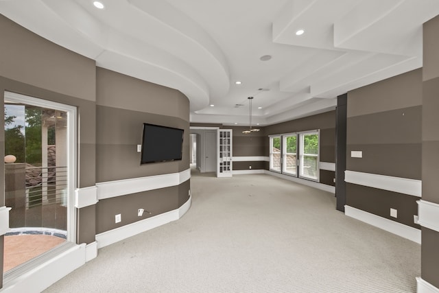 unfurnished living room featuring carpet floors, recessed lighting, baseboards, and a raised ceiling