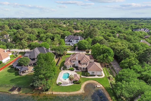 bird's eye view with a water view and a wooded view