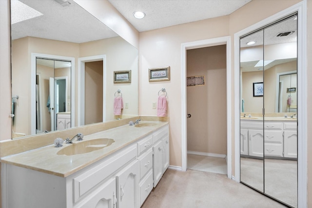full bath featuring double vanity, visible vents, and a sink