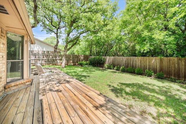 wooden terrace featuring a fenced backyard and a yard