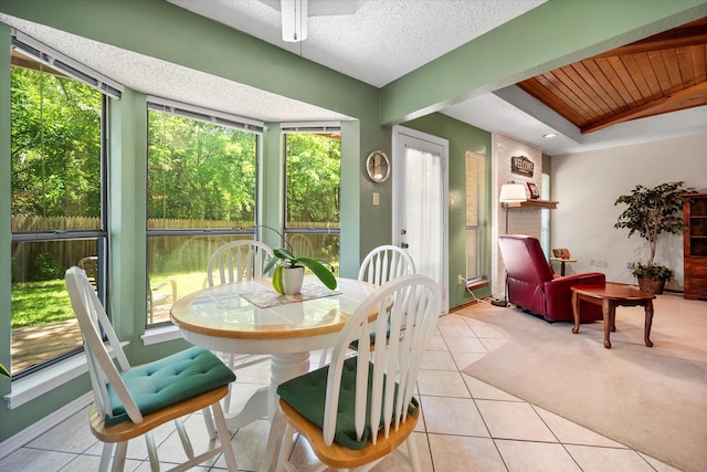 sunroom / solarium with tile patterned floors, a textured ceiling, and wooden ceiling