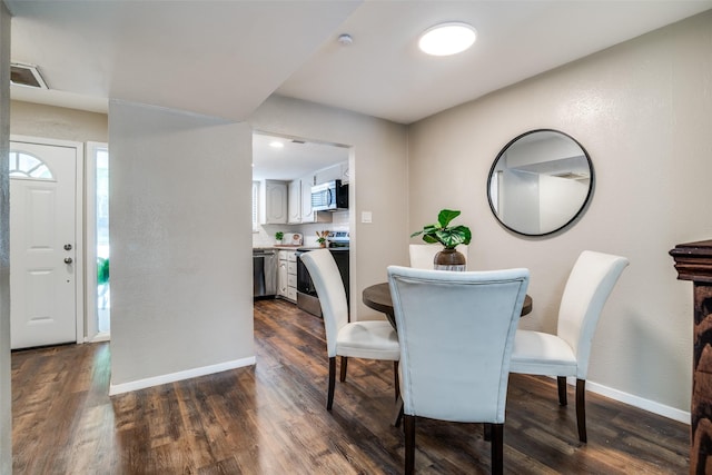 dining room featuring baseboards and dark wood finished floors