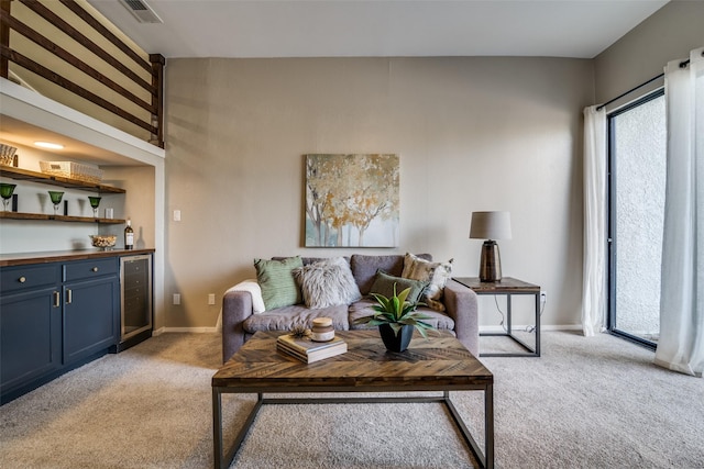 living area with visible vents, a dry bar, baseboards, beverage cooler, and light carpet