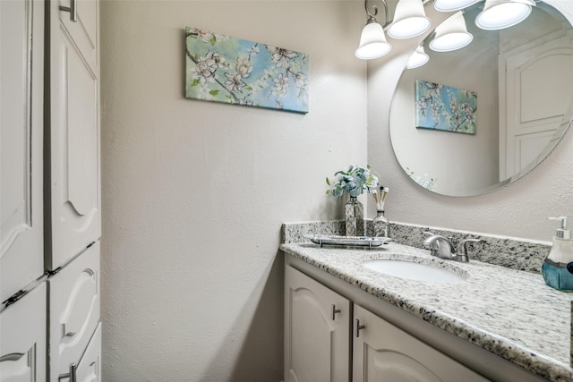 bathroom featuring vanity and a textured wall