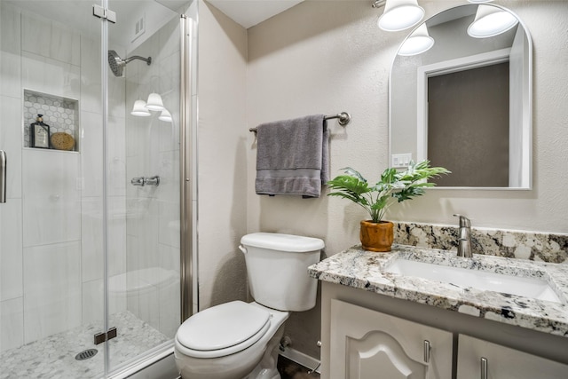full bathroom featuring toilet, visible vents, a shower stall, and vanity