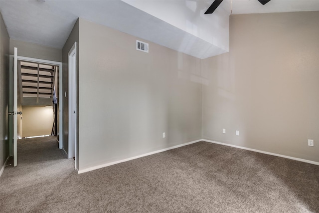 carpeted empty room featuring visible vents, a ceiling fan, and baseboards