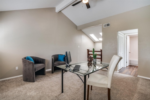 dining room featuring vaulted ceiling with skylight, ceiling fan, visible vents, baseboards, and carpet